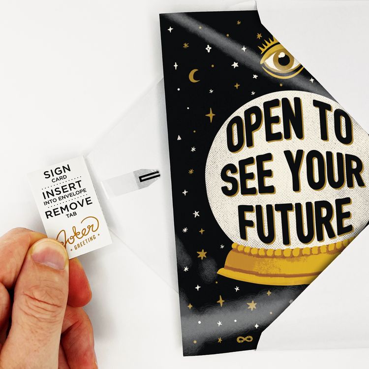 Hand holding tab removal system on endless fortune teller musical card showing Joker Greeting branding and activation instructions