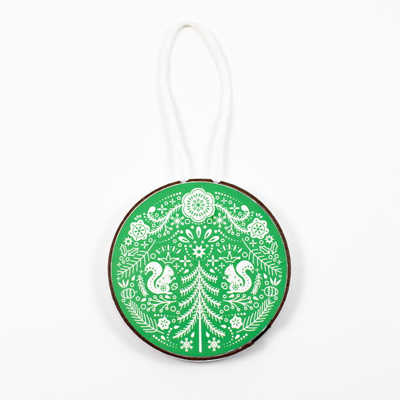 A round ornament with a green and white pattern featuring bird motifs, designed to be hung on a tree.