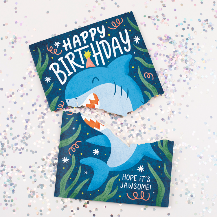 Torn Card with Glitter:
Baby Shark birthday card torn in half with chunky multicolored glitter scattered around showing hidden glitter surprise defense system