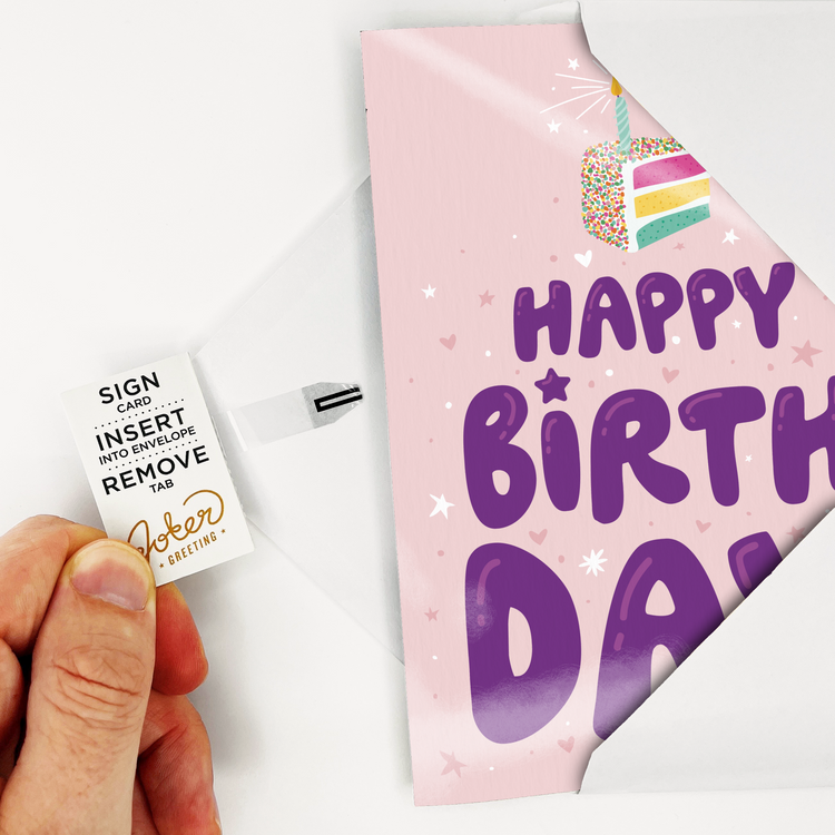 Card with Tab Demonstration:
Hand demonstrating Birthday Cake punk rock musical prank card with Joker Greeting instruction tab showing Sign Card Insert Into Envelope Remove Tab activation process
