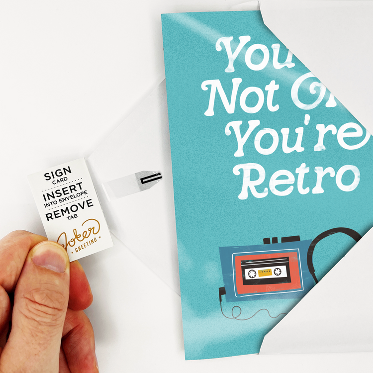 Hand demonstrating Joker Greeting card tab removal system with sign card insert into envelope remove tab instructions for endless musical activation