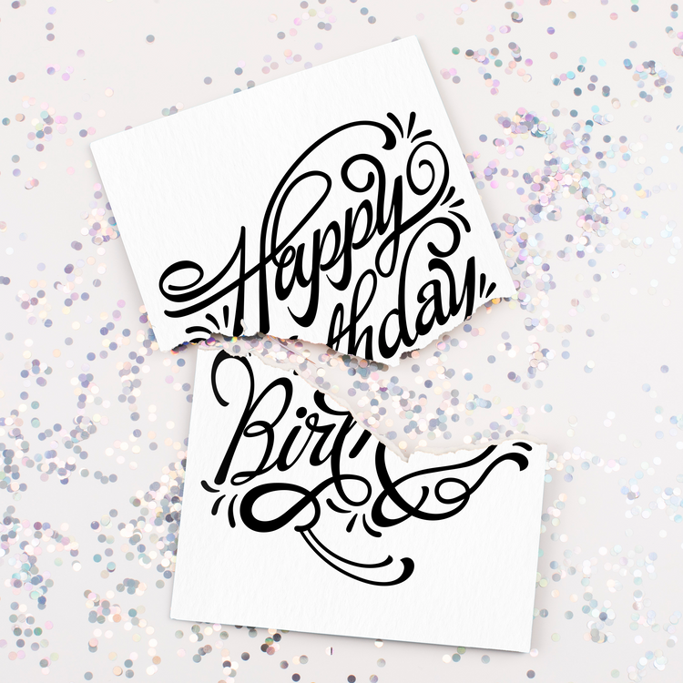 Glitter on Table – Joker Greeting birthday card ripped in half surrounded by silver glitter fallout.