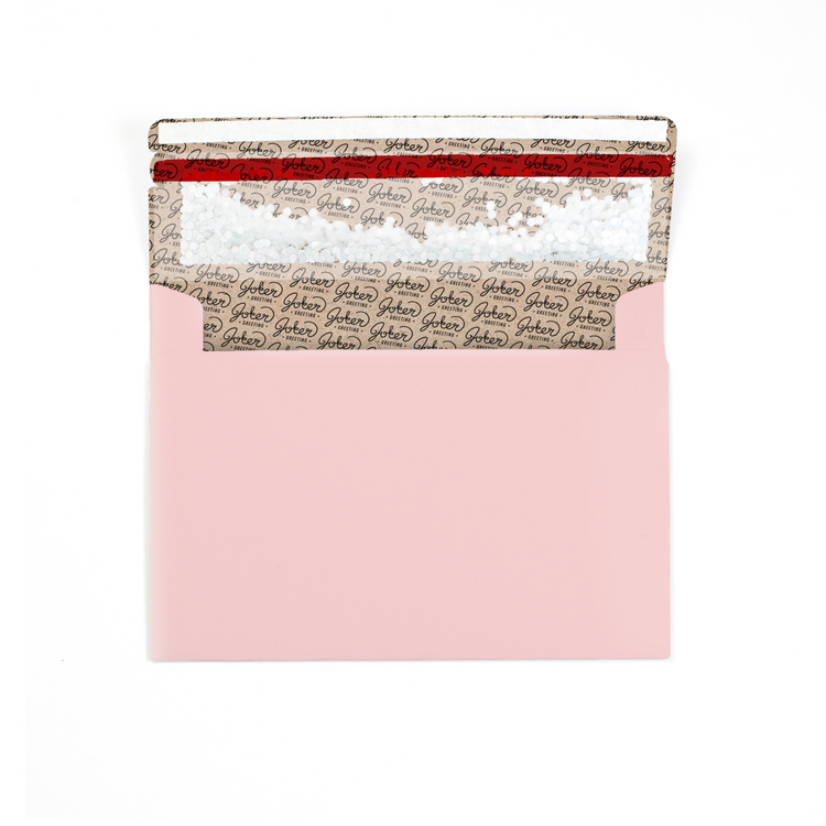 (Envelope with branded interior visible): Joker Greeting blush pink glitter envelope showing interior branding and prank mechanism in romantic blush color