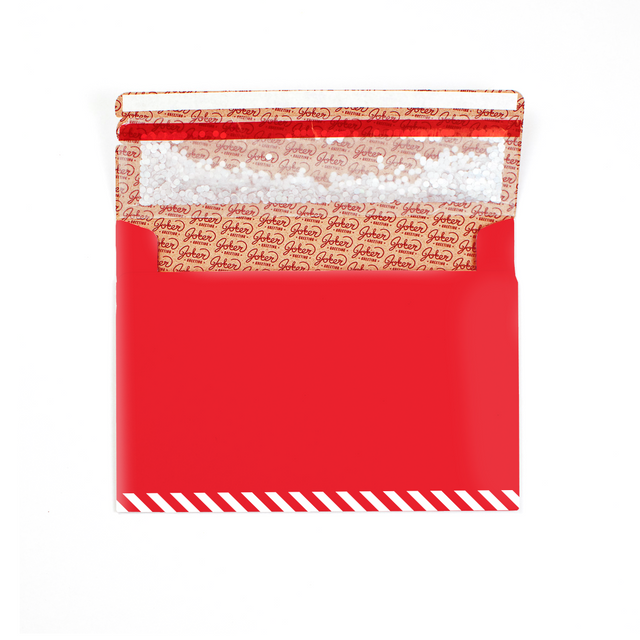 Open red Christmas glitter trap envelope with white diagonal stripes and Joker Greeting pattern interior showing large bio glitter visible inside
