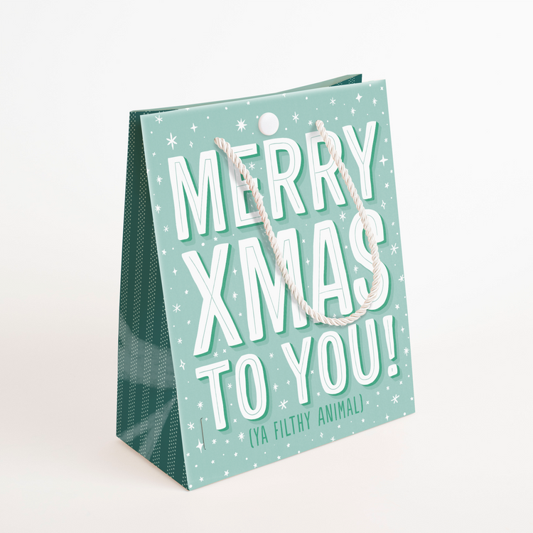 Standing view of endless meowy Christmas musical gift bag featuring Merry Xmas Ya Filthy Animal text with premium white rope handles and button closure