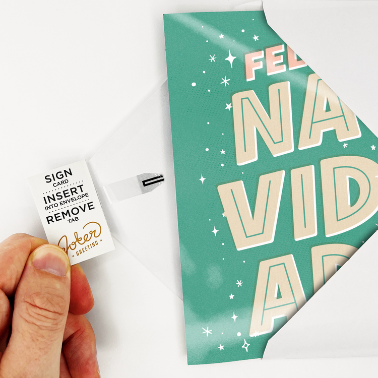 Hand holding Joker Greeting Feliz Navidad musical card showing removal tab activation system for endless Christmas music