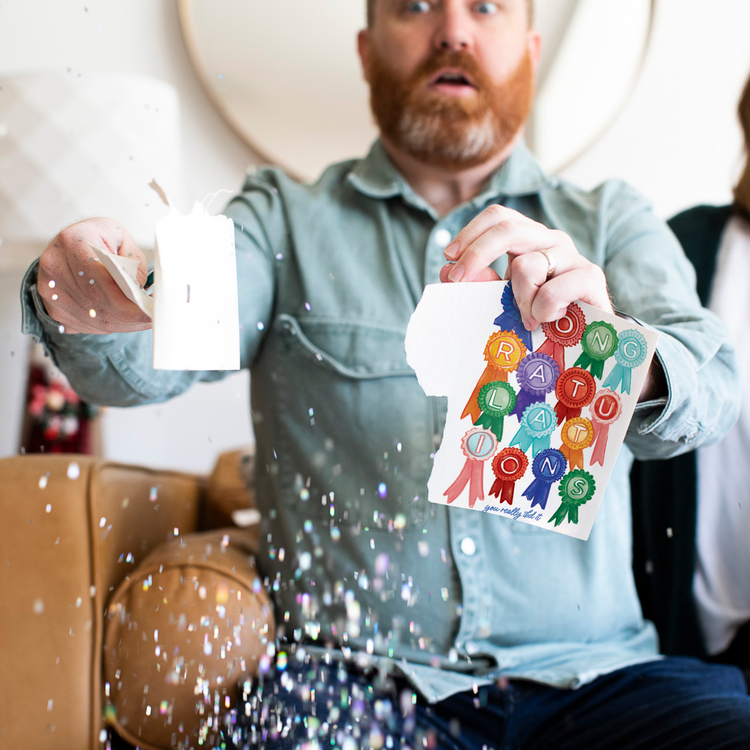 Person holding activated Joker Greeting congratulations card with large glitter falling and surprised expression showing endless musical prank in action