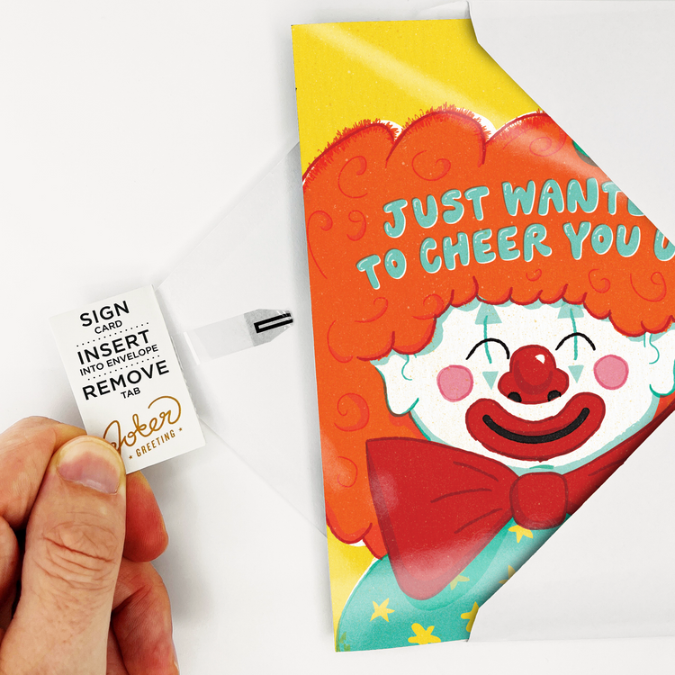 Hand holding Joker Greeting endless musical encouragement card with cheerful clown design and tab removal instructions