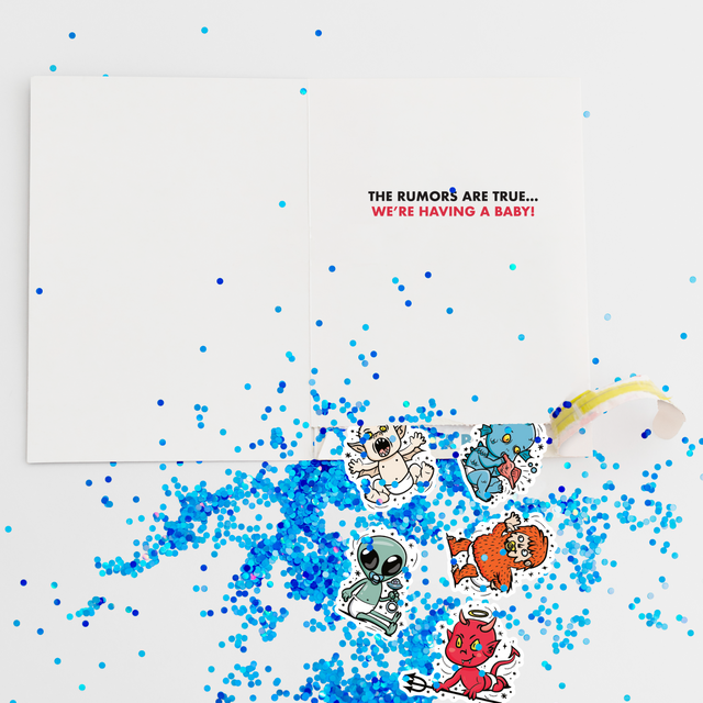 Gender reveal boy prank card with blue glitter and cartoon character stickers scattered around newspaper-style greeting card