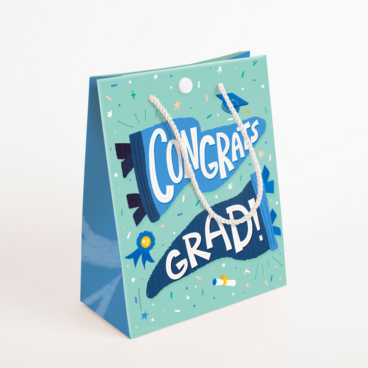 Side angle of endless graduation prank bag with rope handles showing blue and green celebratory design. Closed Bag.