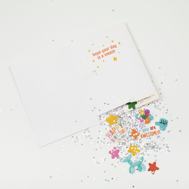 Card with Pull Strip Demo:
Open piñata birthday card demonstrating pull strip mechanism with glitter and stickers spilling out showing Hope Your Day Is A Smash message and colorful surprises