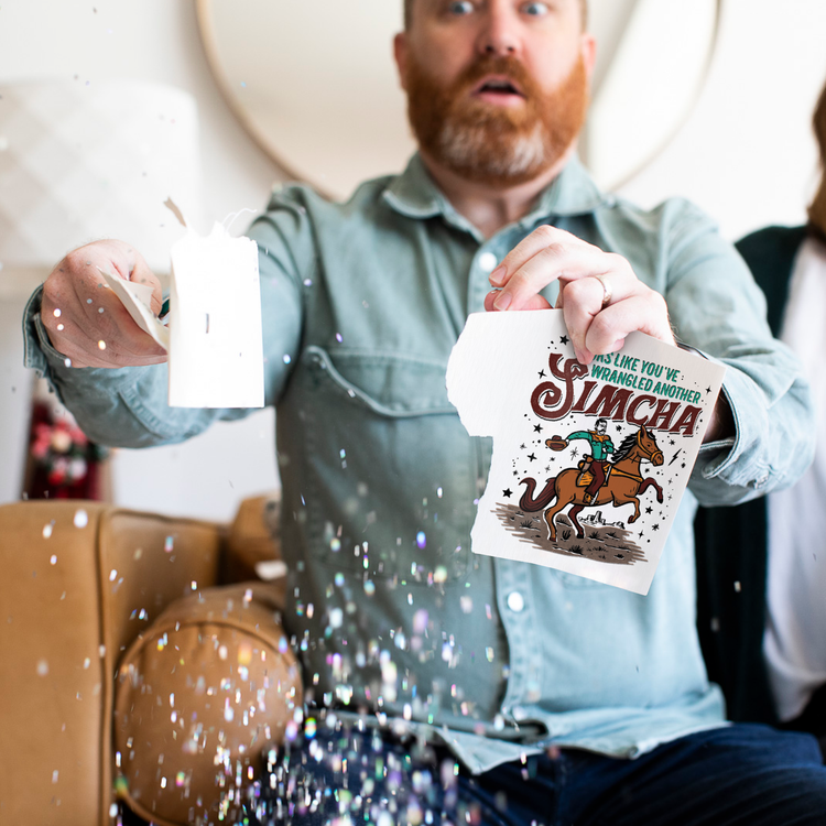 Person holding activated Joker Greeting Simcha card with large glitter falling and surprised expression showing endless musical prank in action