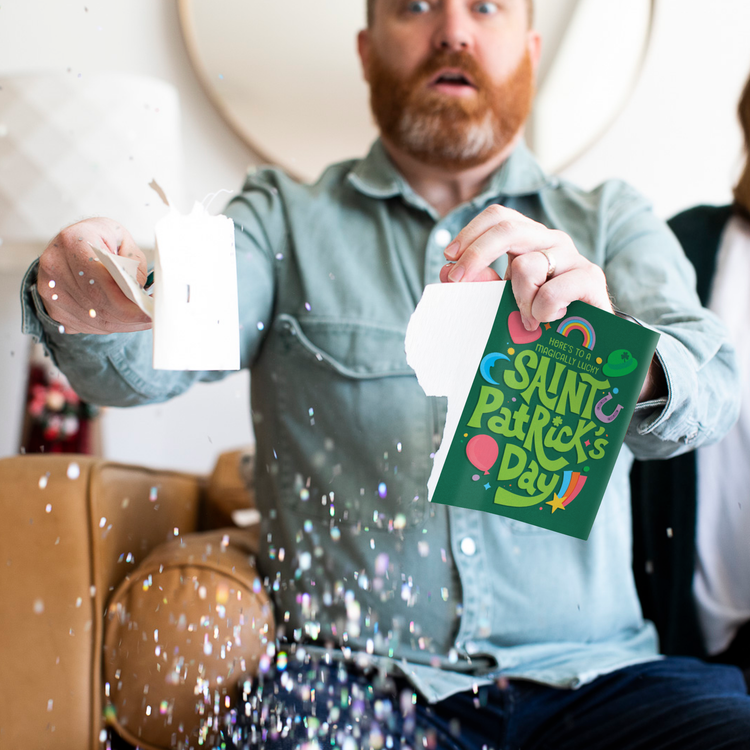 Man ripping St. Patricks Day card opened with glitter falling around it