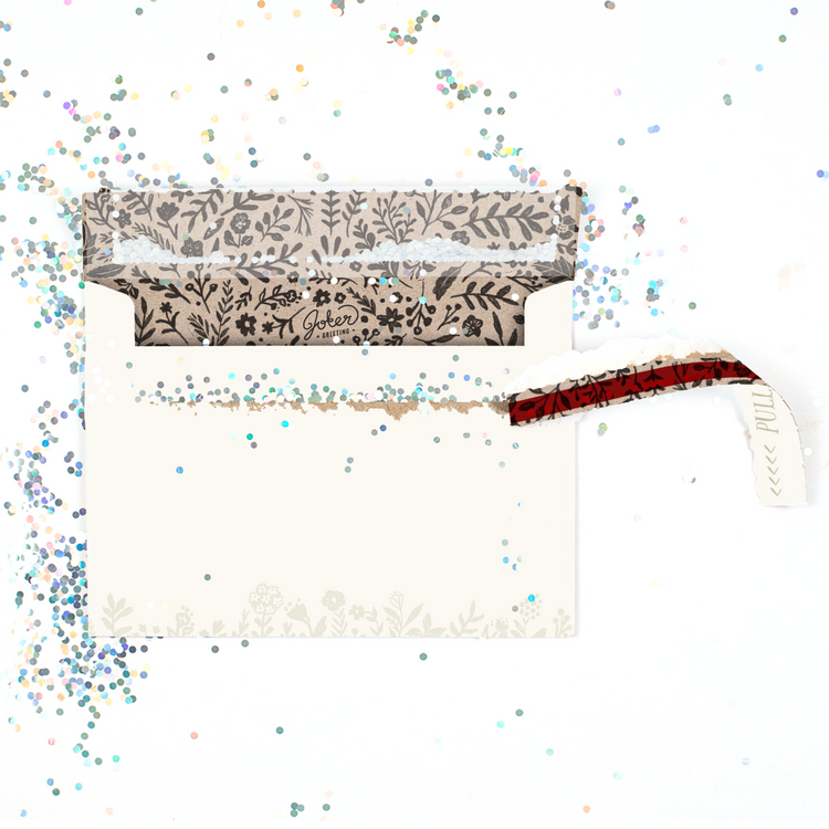 (Final result with glitter scattered): Floral prank envelope opened with multicolored glitter scattered showing successful sophisticated glitter trap result