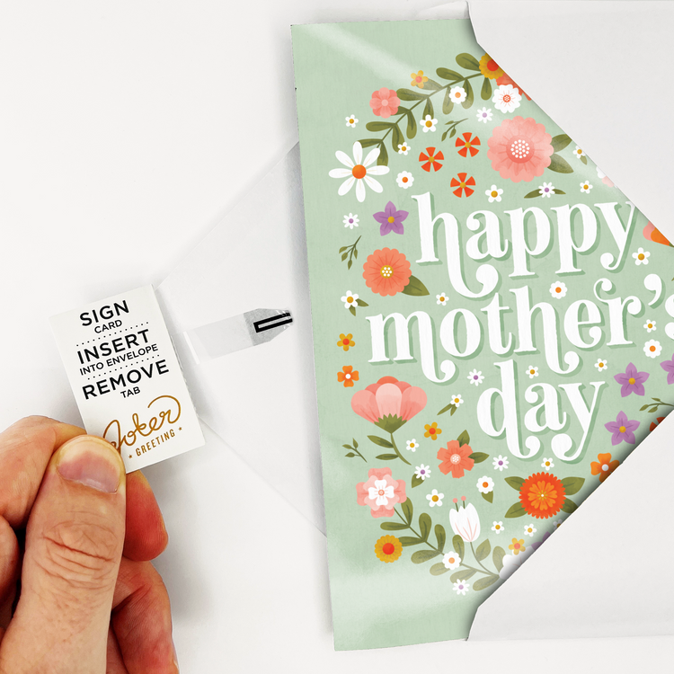 Hand holding Joker Greeting pull tab for Mother's Day baby crying sound card with floral design visible