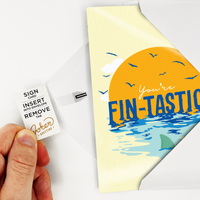 Hand pulling tab out of card to arm it. Instructions showing. 