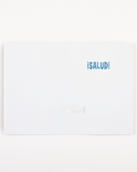 White greeting card with blue text '¡Salud!' on a white background
