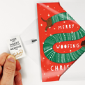 Hand pulling tab to arm greeting card. 