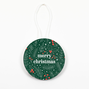 A round ornament with a green background featuring a festive pattern, including 'merry christmas' text and decorative elements. A string for hanging is visible at the top.
