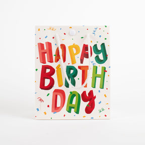 Front view of Happy Birthday musical prank gift bag with colorful 3D lettering and confetti pattern design