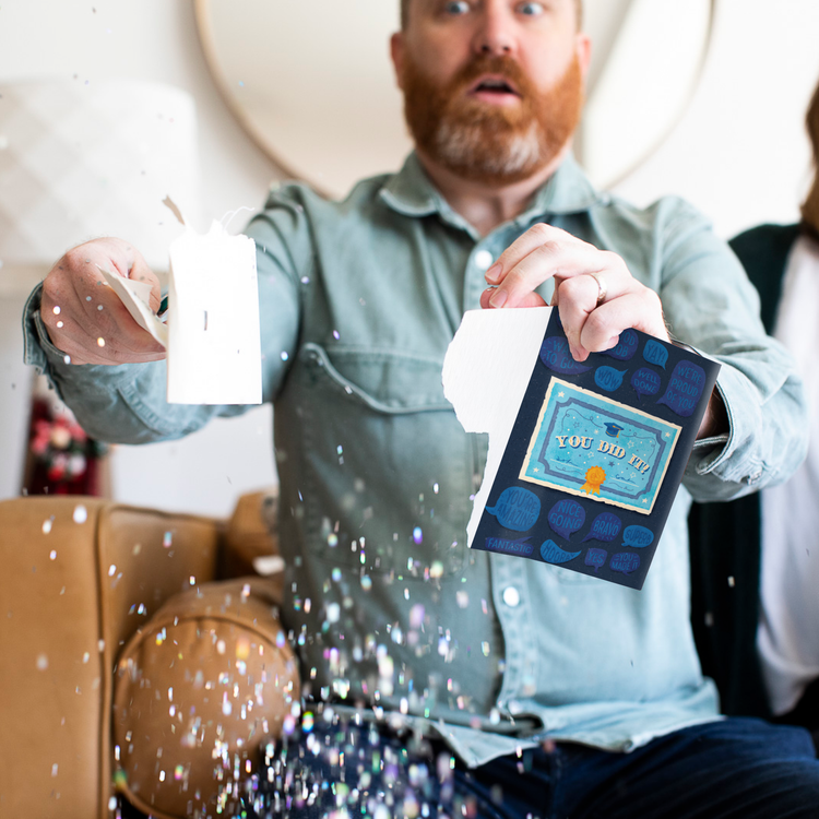  Person holding activated Joker Greeting graduation card with you did it message and large glitter falling showing endless musical prank in action