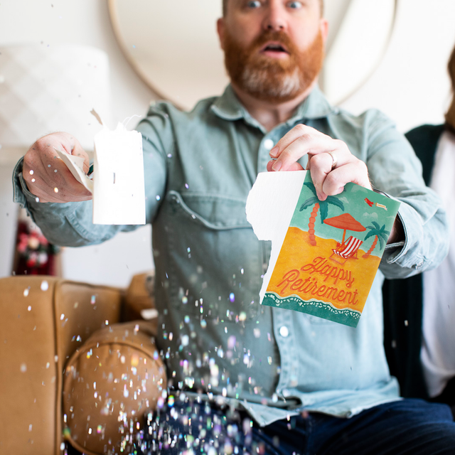 Man ripping the retirement card showing glitter all around