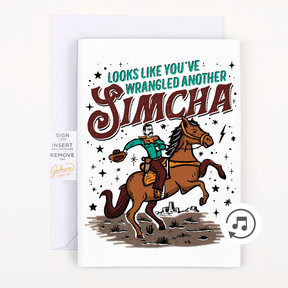 A greeting card with an illustration of a person on a horse and text that reads 'LOOKS LIKE YOU'VE WRANGLED ANOTHER SIMCHA'. There is also a note about including plain white envelopes and the longevity of the glitter.