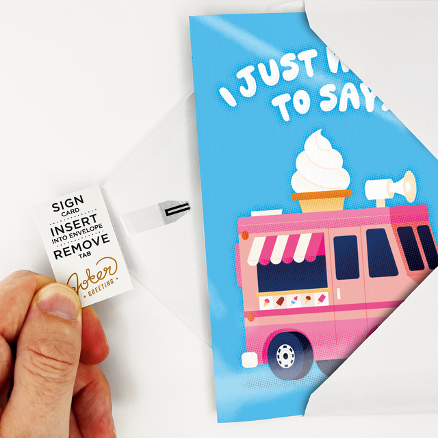 Hand holding Joker Greeting ice cream card with removal tab instructions visible on white envelope