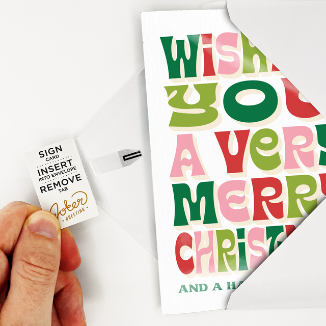 Christmas card with colorful text and a hand holding a small sign.