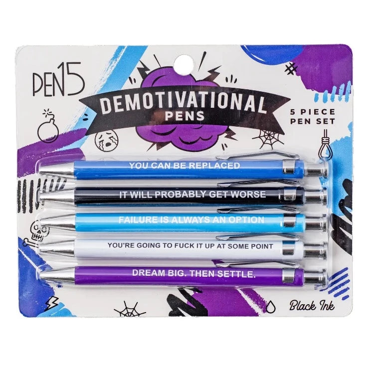 A set of five pens packaged in a box with demotivational phrases on each pen. The phrases include 'You can be replaced', 'It will probably get worse', 'Failure is always an option', 'You're going to f*ck it up at some point', and 'Dream big.